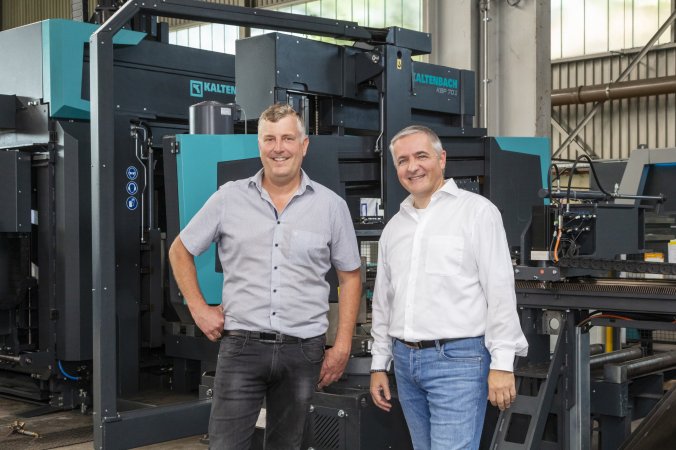 Bernd Graf von Schwarzwald Eisen und Andreas Pregger von Kaltenbach gemeinsam vor der innovativen Säge-Bohr-Anlagen Kombination für die Stahlbearbeitung